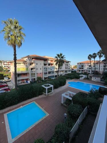 - une vue de tête sur deux piscines d'une ville dans l'établissement Dernier étage avec garage, piscines et tennis, à Cagnes-sur-Mer