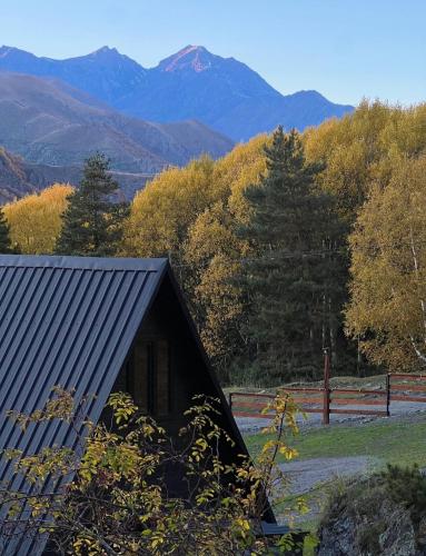 a small cabin with a mountain in the background at Mountain Waltz by Elia Glamping in Stepantsminda