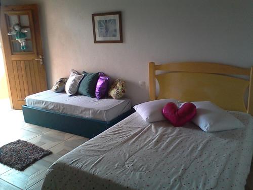 a bedroom with two beds and a heart pillow at Estudio dos Bonecos in Canela