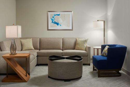 a living room with a couch and a chair at Hilton West Palm Beach in West Palm Beach
