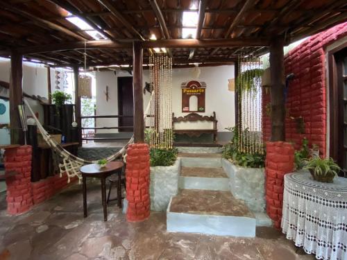 a room with a red brick wall and a staircase at Pousada E Restaurante Passart in Morro de São Paulo