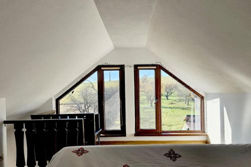 Un dormitorio con una cama y una ventana grande. en FLH - Livada Bunicilor, en Almaş