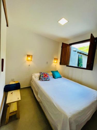 a small bedroom with a bed and a window at CASA JASMIM, vila florescer, centro histórico!! in Piranhas