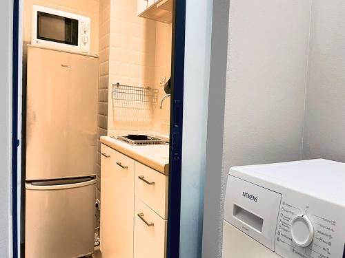 a small kitchen with a refrigerator and a microwave at Green Residence Hotel in Bang Rak Beach