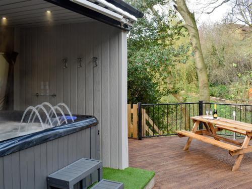 a deck with a bench and a picnic table at Bridge House in Loftus