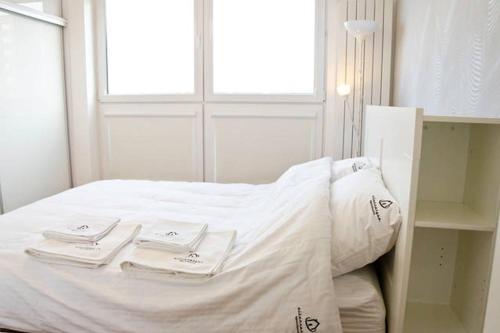 Una cama blanca con toallas en una habitación en Modern & Functional Apartment Wwa, en Varsovia