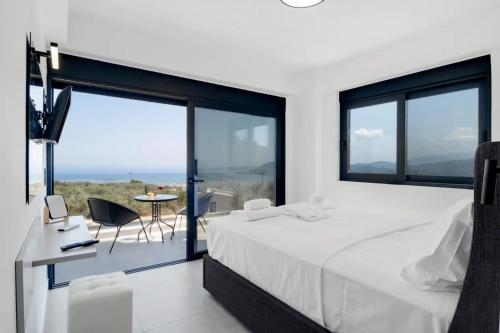 ApolpainaにあるVilla Andriaのベッドルーム(白い大型ベッド1台、デスク、椅子付)