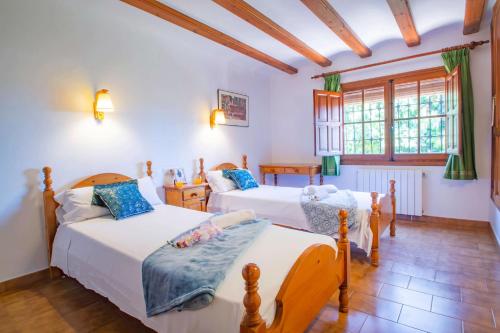 テウラーダにあるVilla Rocky - Plusholidaysのベッド2台と窓のある寝室