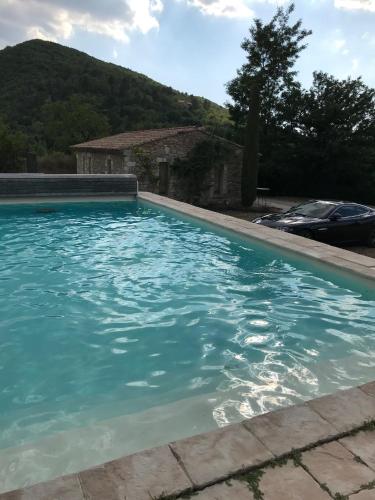 une piscine avec de l'eau bleue devant une maison dans l'établissement Mas Beauregard - maison avec piscine, à Dauphin