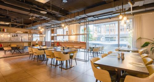 a restaurant with tables and chairs and a large window at Aiden by Best Western Biberach in Biberach an der Riß