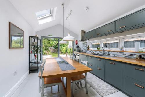 una cucina con armadi blu e tavolo in legno di Peaceful 3 bedroom Victorian Cottage a Honiton