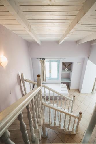 a staircase in a house with white walls and wooden ceilings at PARALIA Stoudios in Parga