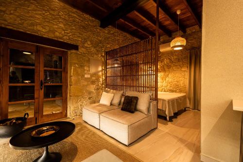 a living room with a couch and a bed at Harma Traditional Boutique Suites in Paphos City