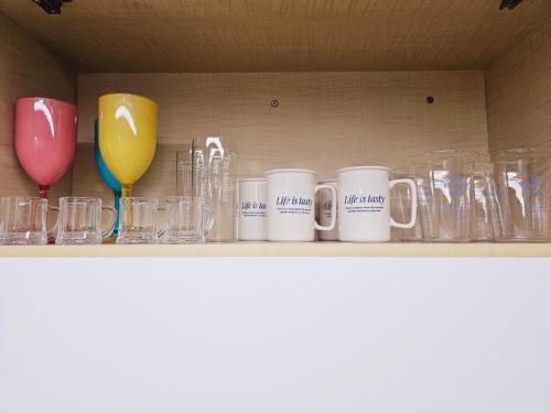 a shelf with mugs and glass items on it at 인천시청 길병원 인천터미널역 롯데백화점 앞 인기숙소 in Incheon