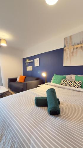 a large white bed in a room with a couch at Modern spacious Studio opposite station II in London