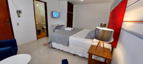 a hotel room with a bed and a television at Pousada Solar de Itaúna in Saquarema