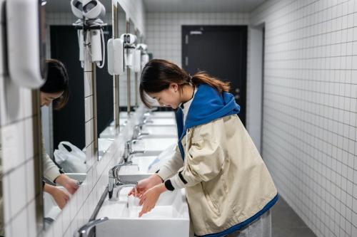 two women are washing their hands in sinks at Dayin Garden Hotel -People's Square & Nanjing Road-Large Social Area -Bar -Café -Gym -Free Laundry Luggage Storage -24H Front Desk-English Service in Shanghai
