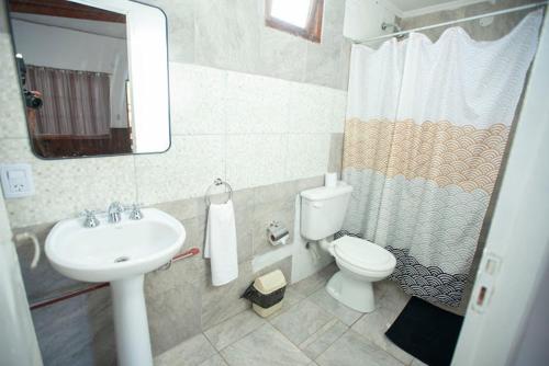 a bathroom with a sink and a toilet and a mirror at Iguazú Green Hotel in Puerto Iguazú