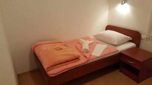 ein kleines Bett mit einer Decke und einem ausgestopften Tier darauf in der Unterkunft Guest House Zarko & Mara in Međugorje
