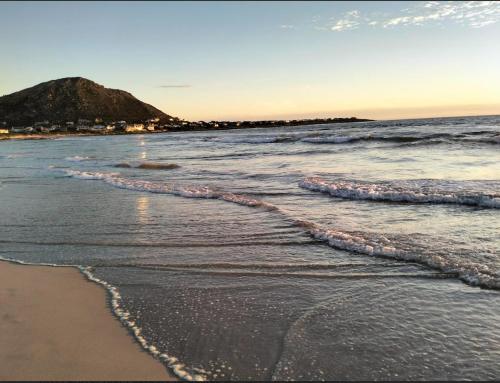 a beach with waves coming in from the ocean at C es Cape in Pringle Bay