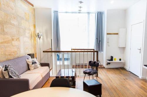 un salon avec un canapé et une table dans l'établissement échoppe 2 à 6 personnes, à Bordeaux