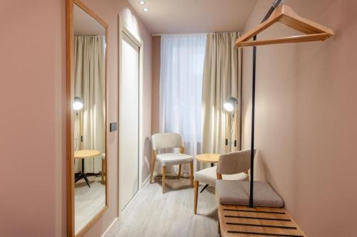 a room with a mirror and a table and chairs at Terra Hotel Boutique in Tirano