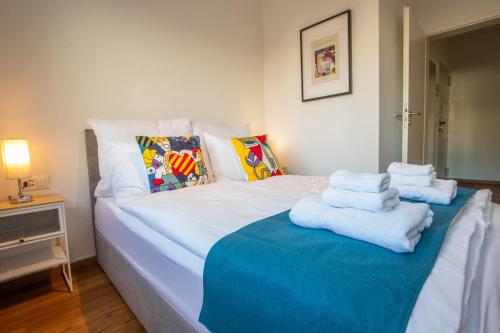 a bedroom with a large white bed with towels on it at Special PRIMERO PICASSO Apartment Basel, Bahnhof Grossbasel 10-STAR in Basel