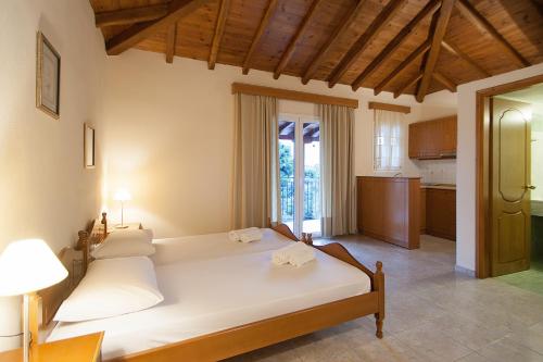 a bedroom with two beds and a kitchen at Villa Alissia in Koukounaries