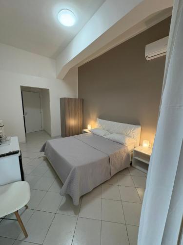 a bedroom with a large bed and a chair at Grillo in Salerno