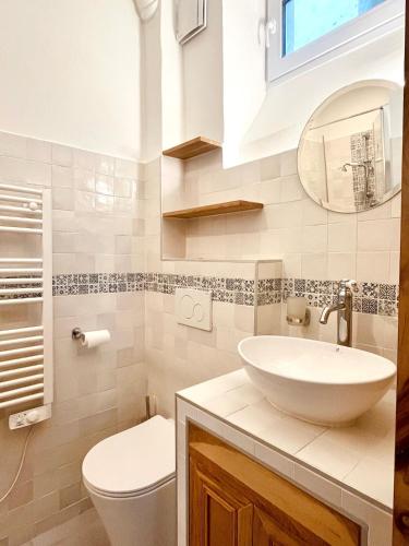 une salle de bain avec un lavabo, des toilettes et un miroir dans l'établissement Le Penthouse du Sacré-Coeur, à Paris