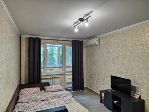a bedroom with a bed and a flat screen tv at Центр Проспект Центральный 184 АТБ in Mykolaiv
