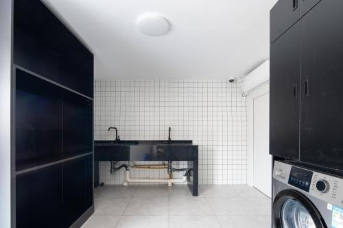 a bathroom with a black sink and white tiles at Dayin Youth Hostel - Old Town & People's Square& Rail Hub -Social Area -Bar -Café -Gym -Free Laundry Luggage Storage -24H Front Desk -English Service in Shanghai