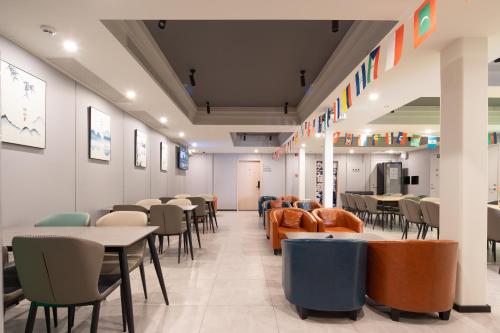 a restaurant with tables and chairs in a room at Dayin Youth Hostel - Old Town & People's Square& Rail Hub -Social Area -Bar -Café -Gym -Free Laundry Luggage Storage -24H Front Desk -English Service in Shanghai