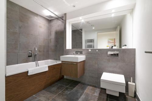 a bathroom with a sink and a tub and a mirror at Bull Inn Court - Walking distance to Covent Garden Square in London