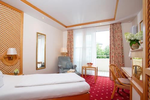 a hotel room with a bed and a window at Thermenhotel Quellenhof in Bad Füssing