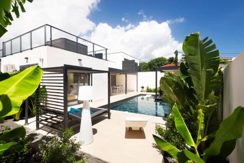 a house with a swimming pool and plants at Lagon Paradis - 6 Villas individuelles avec Piscine ou Jacuzzi - Loc Voiture Cabriolet ou SUV in Le Gosier