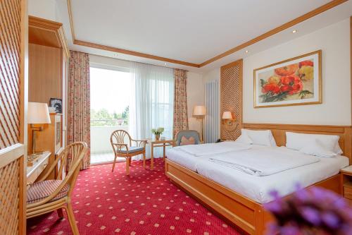 a hotel room with a bed and a table at Thermenhotel Quellenhof in Bad Füssing
