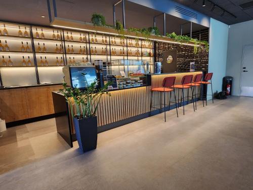 a restaurant with a bar with chairs and a counter at Campanile La Roche Sur Yon Centre Gare in La Roche-sur-Yon