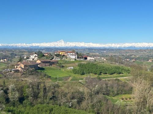 a house on a hill with mountains in the background at Splendid Villa Magna with Pool and Park - Langhe Hills in Govone
