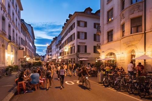 a group of people walking down a city street at Special PRIMERO PICASSO Apartment Basel, Bahnhof Grossbasel 10-STAR in Basel