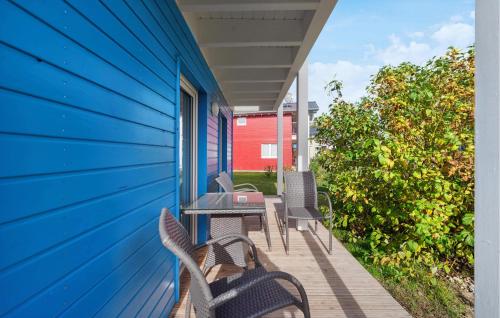 a blue house with chairs and a table on a porch at Seehund Xl in Süssau