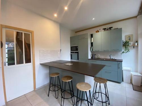 - une cuisine avec un comptoir et des tabourets dans l'établissement Les Mimosas, plage 200mètres, à Saint-Pair-sur-Mer