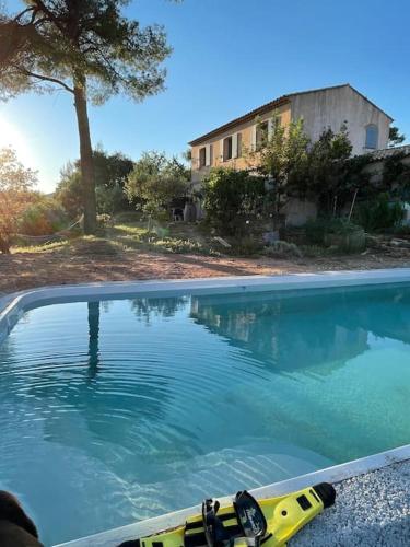 une piscine avec un bateau jaune dans l'eau dans l'établissement Grand T2 sous les pins, à Pourrières