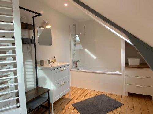 une salle de bain avec un lavabo et une baignoire dans l'établissement Les Mimosas, plage 200mètres, à Saint-Pair-sur-Mer