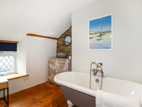 bagno con vasca bianca e pavimenti in legno di Crab Cottage a Delabole