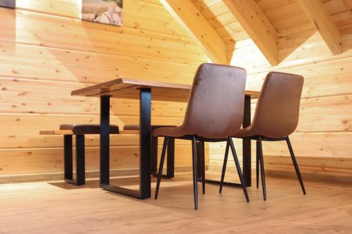 two chairs and a table in a room with wooden walls at Wood Apartments 4 Jahreszeiten in Landl