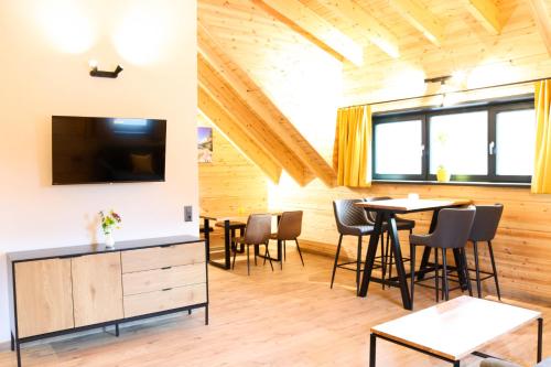 a living room with a table and chairs and a tv at Wood Apartments 4 Jahreszeiten in Landl