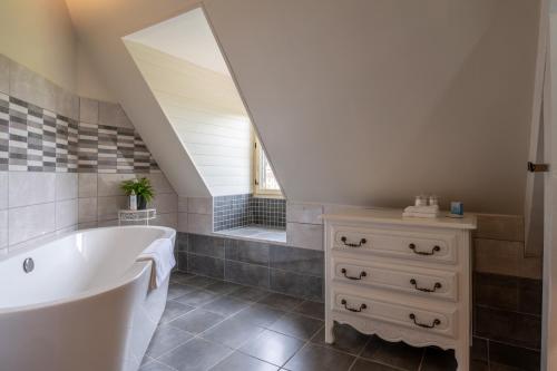 une salle de bain avec une baignoire blanche et un lavabo dans l'établissement Maison de Beaumont, à Beaumont-du-Périgord