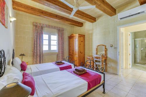 a bedroom with a large bed and a dining room at Villagg tal-Fanal in Għasri