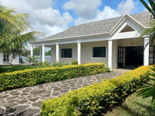 a white house with a stone walkway at N'joy Pereybere Villa in Pereybere